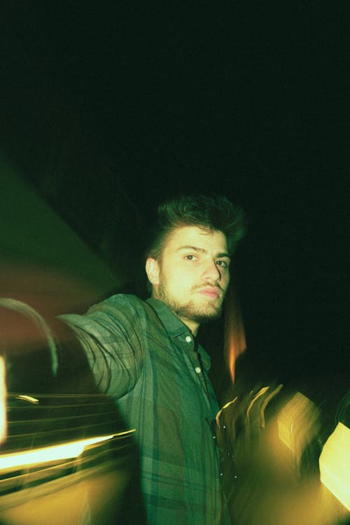 Night Portrait of a Young Brunette Man in a Shirt