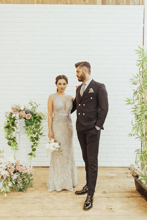 Elegant Bride and Groom Posing Near Flowers