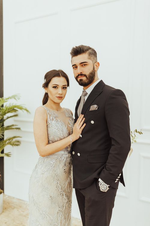 Free A couple elegantly posing in wedding attire indoors, showcasing modern fashion and sophistication. Stock Photo
