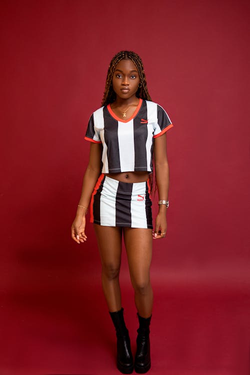 Studio Shoot of a Teenage Model Wearing Striped Clothing, Posing against Red Background