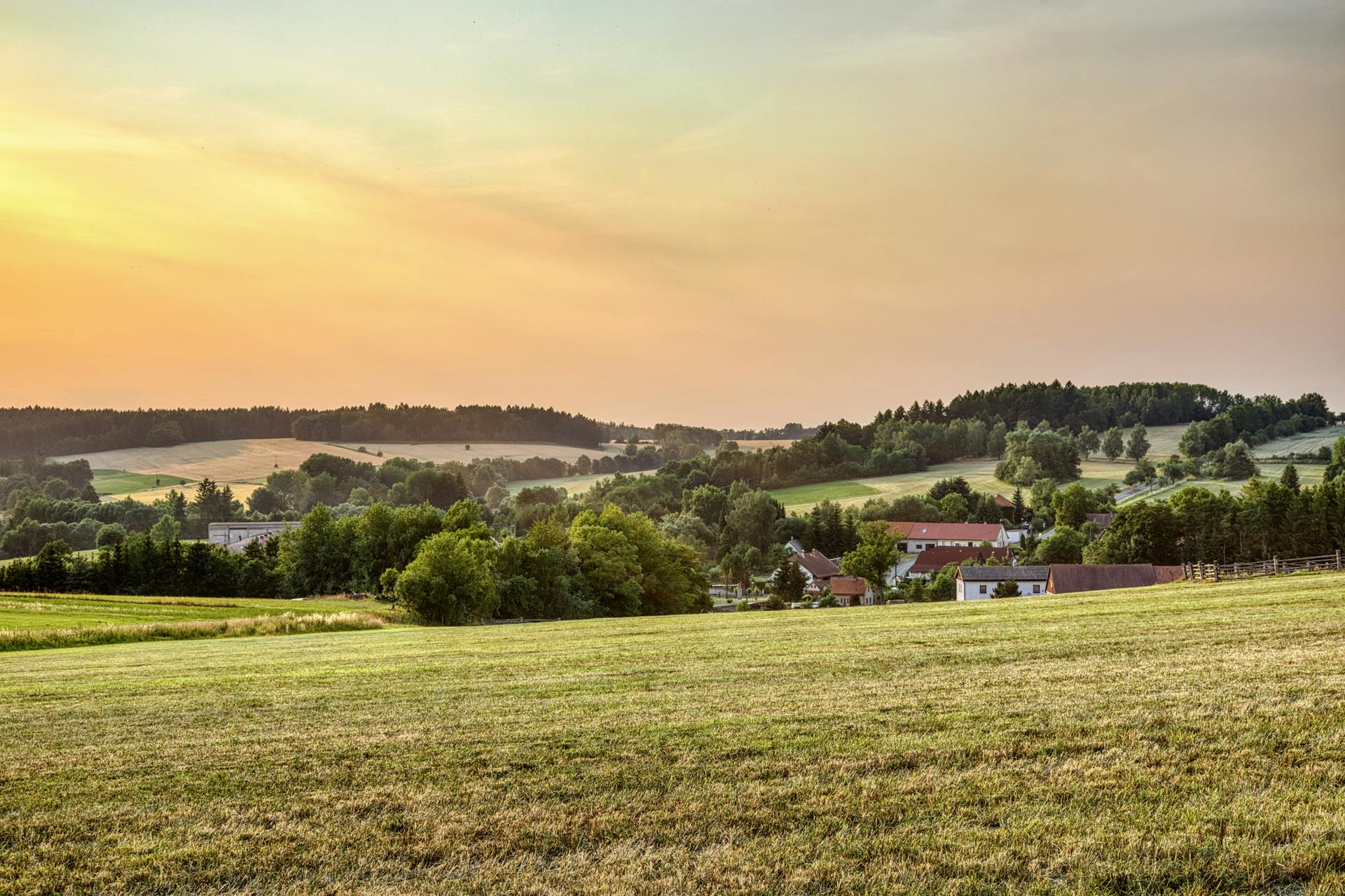 Peaceful rural landscape in Zbraslavice, Czechia at sunset with rolling hills and farmland.