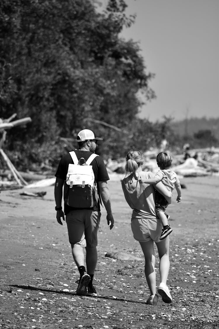 Black And White Photo Of A Family Walking On A Shore