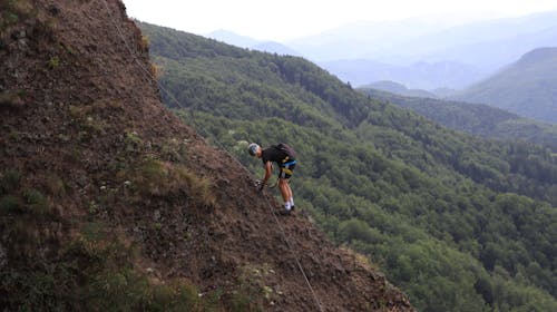 View of a Man Climbing a Rocky Mountain