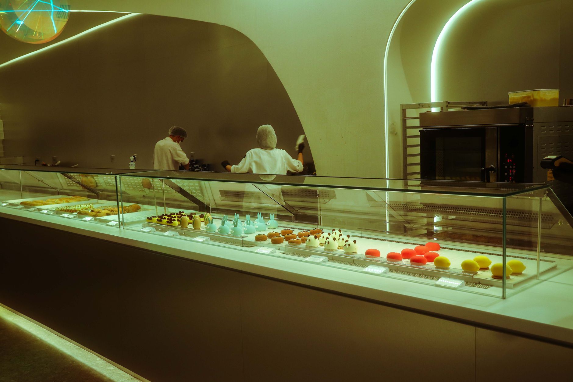 Contemporary bakery showcasing an array of colorful pastries and desserts in a sleek interior.