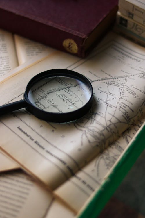 A Magnifying Glass Lying on a Vintage Book with a Map 