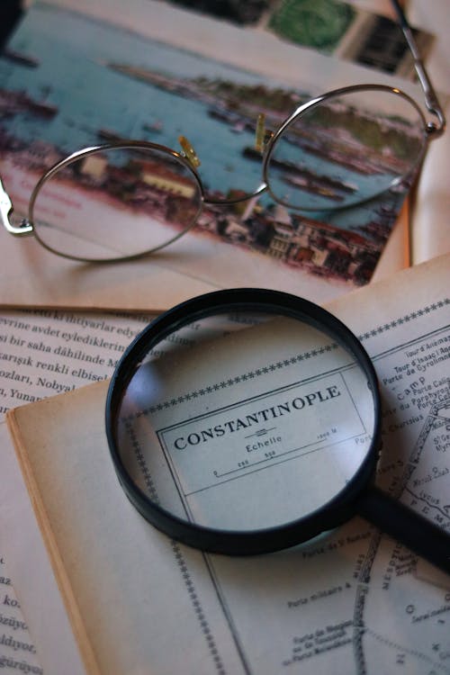 A Magnifying Glass Lying on a Vintage Book with a Map 