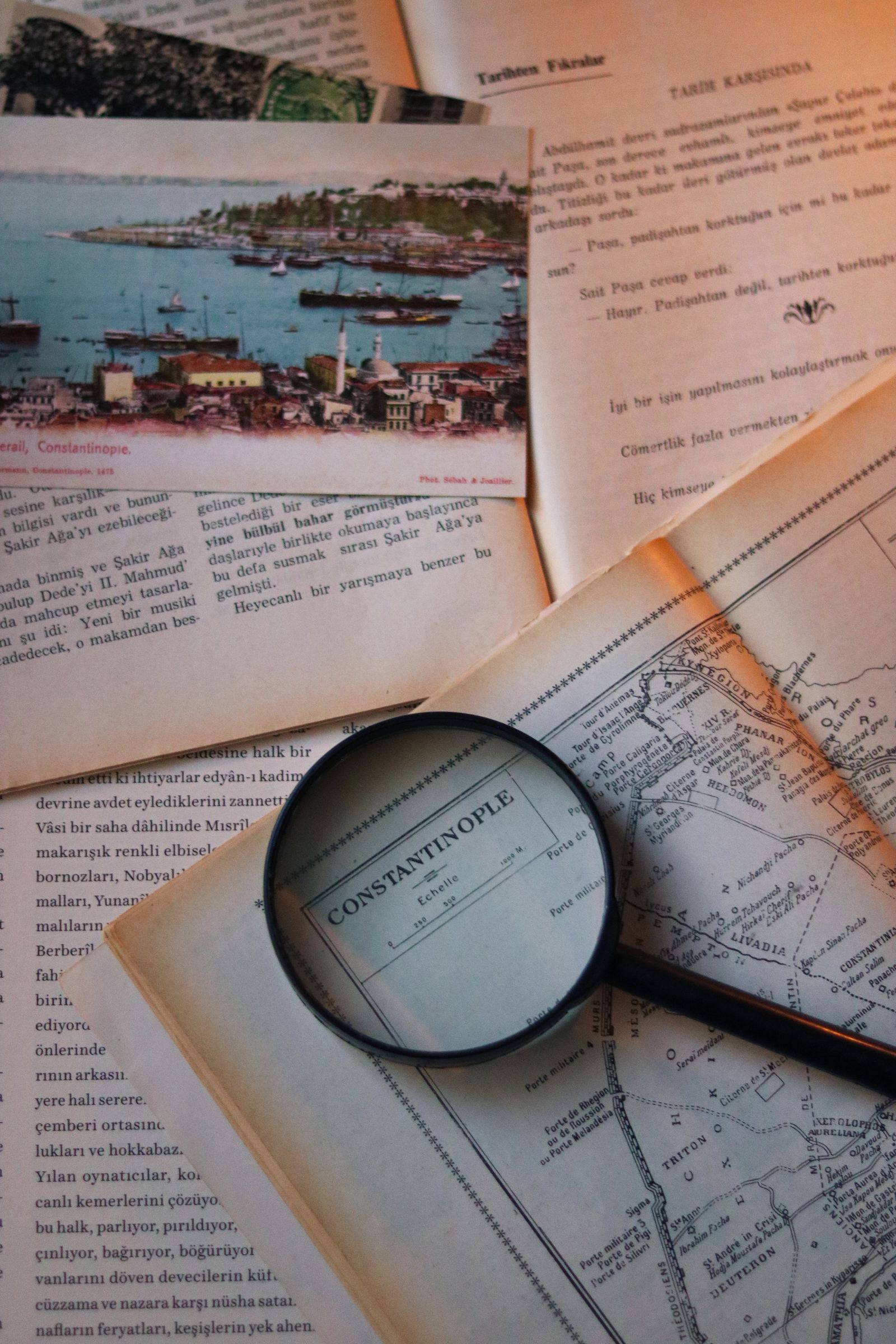 A Magnifying Glass Lying on a Vintage Book with a Map · Free Stock Photo