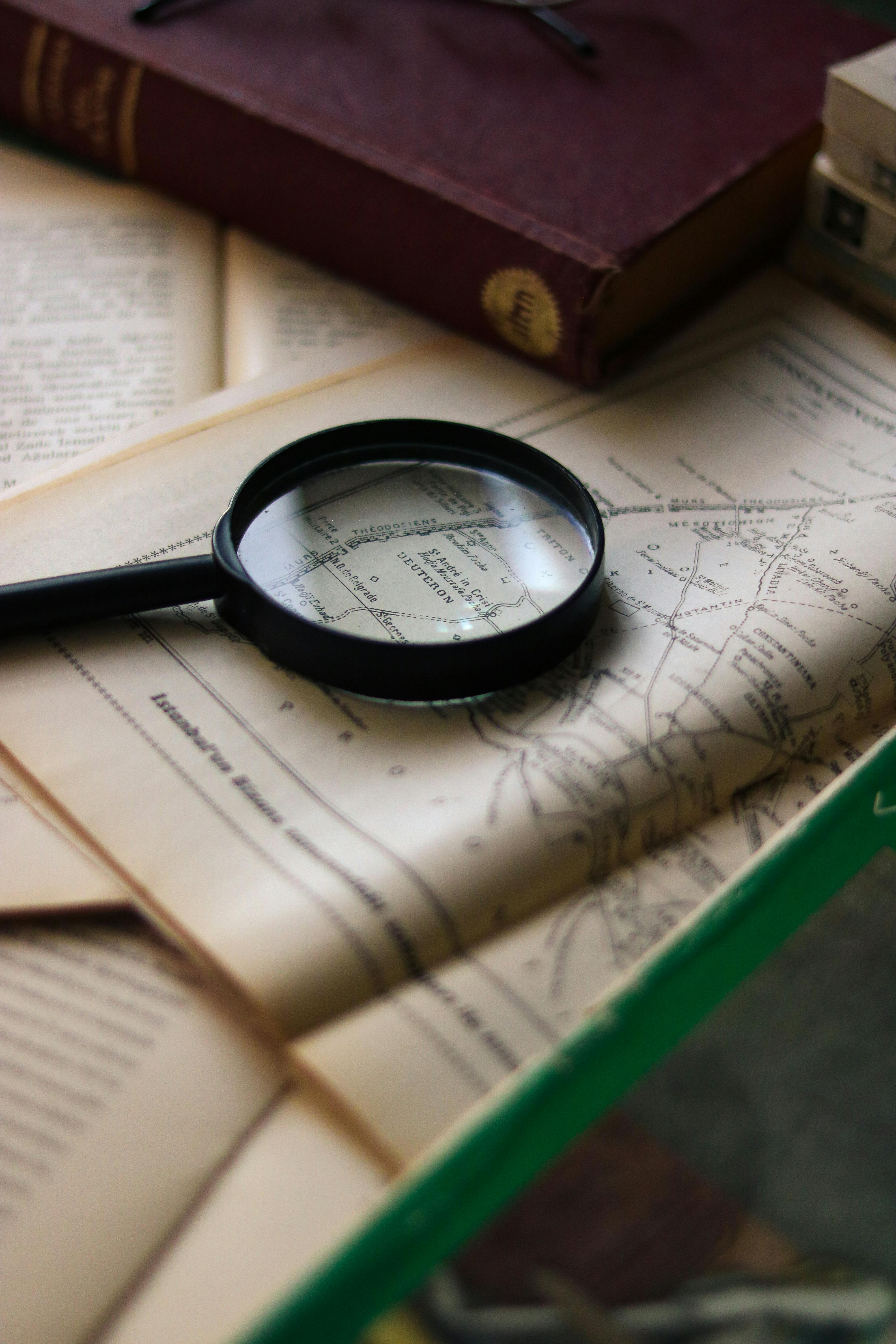 Vintage book and magnifying glass on wooden desk Stock Photo by rawf8