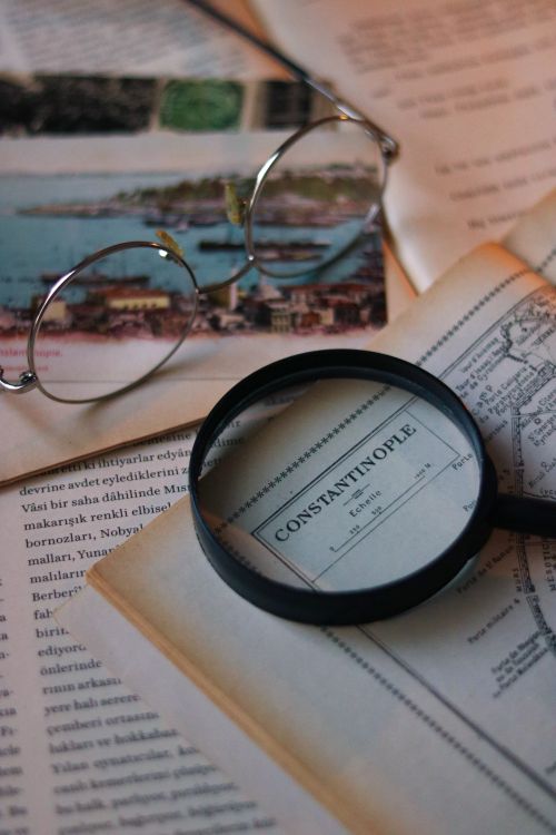 A Magnifying Glass and Eyeglasses Lying on a Vintage Book with a Map ...