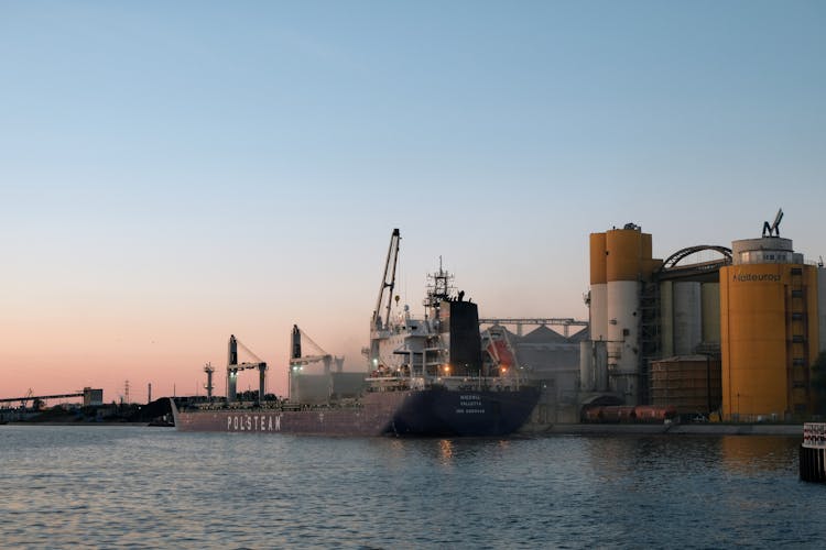 A Large Ship In The Port At Sunset 