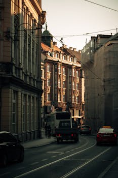 A bustling city street lined with classic architecture and traffic during sunset.