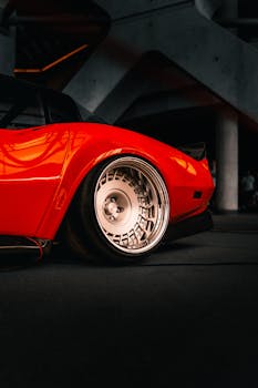 Detailed side view of a classic red Chevrolet Corvette C3 showcasing its stylish wheel design.