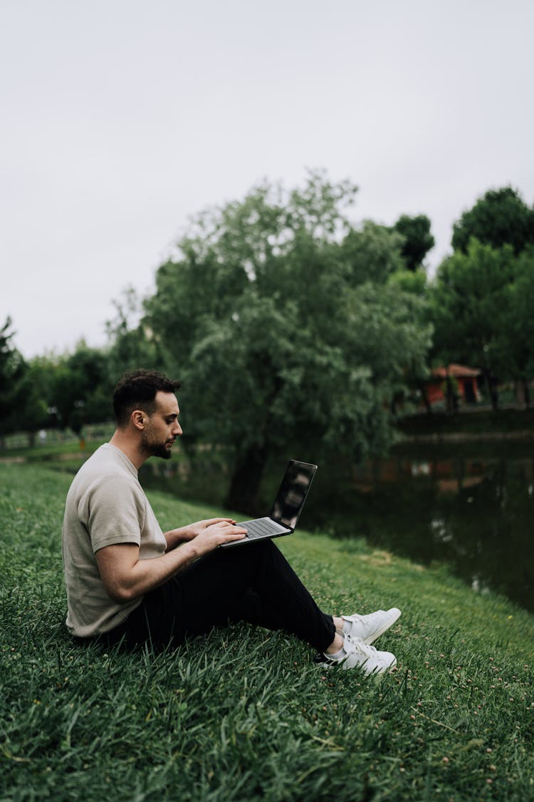 Man Working On Laptop In Park