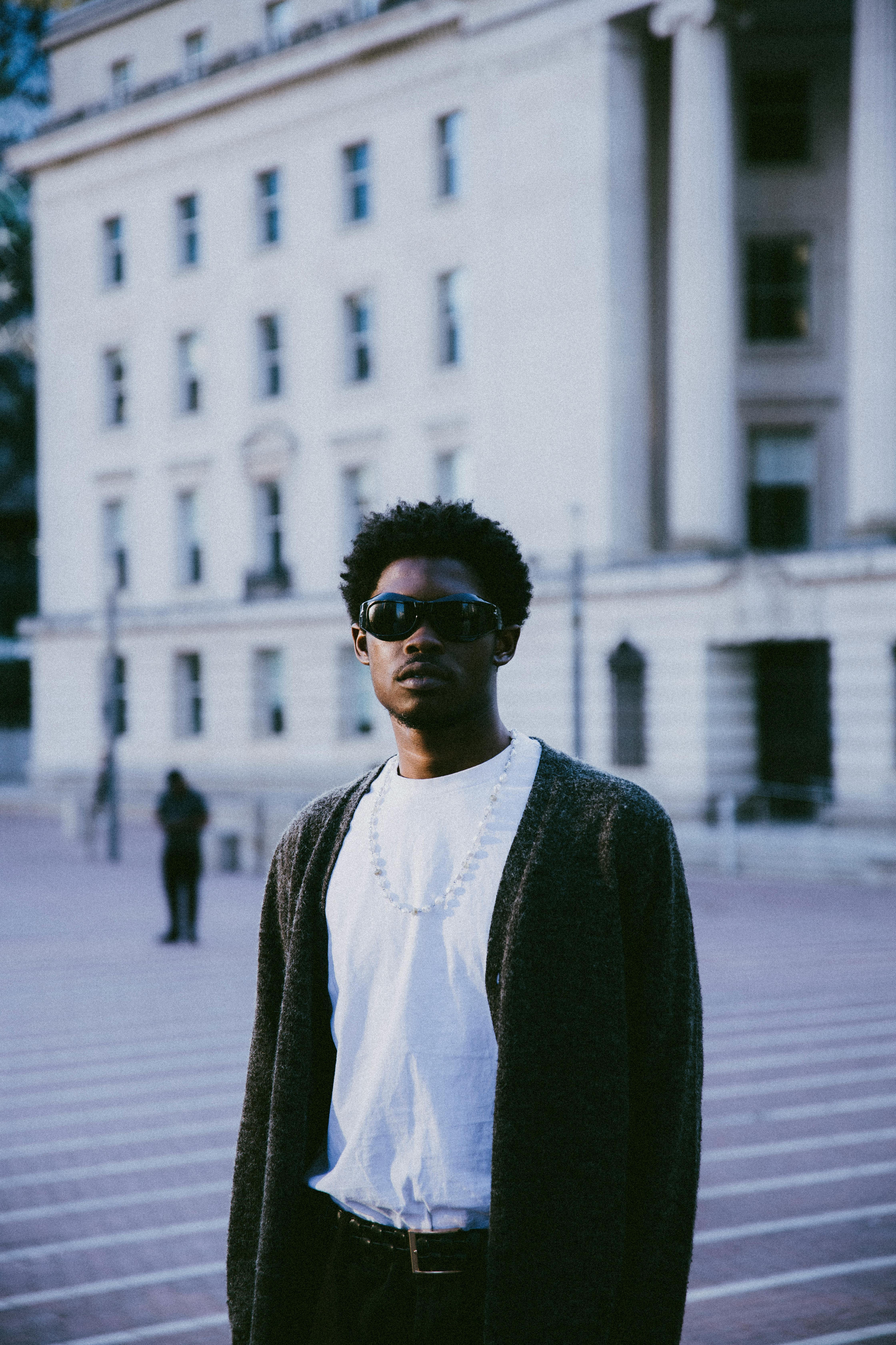 Portrait of a fashionable man standing confidently in an urban environment.