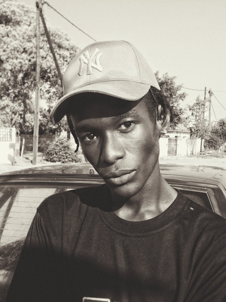 Young Man In A Baseball Car Standing Outside