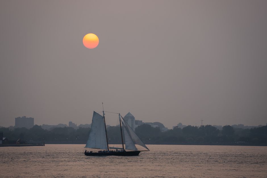 Unforgettable 2.5-hour Guided Sailboat Tour Review: Sailing Past the Brooklyn Bridge and Statue of Liberty Review 2026 - Serene view of a sailboat silhouetted against the sunset on a New York City waterway.