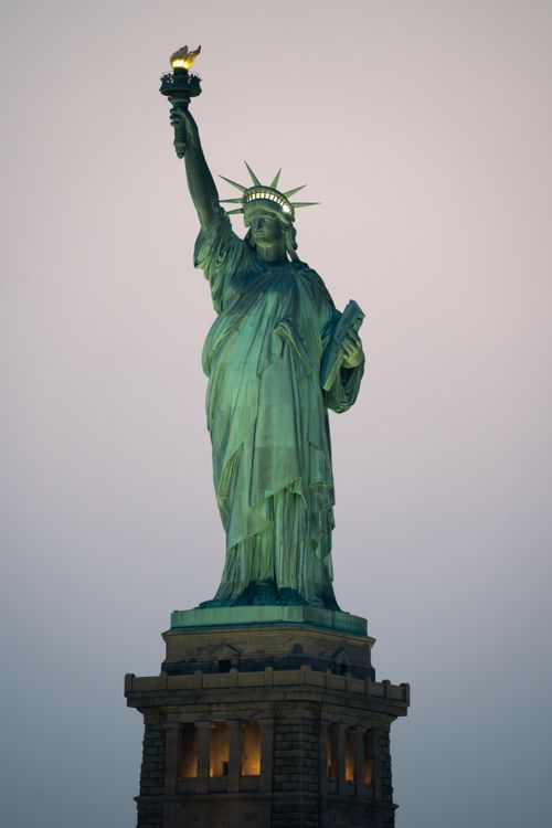 Free Iconic Statue of Liberty against a serene sky in New York City, USA. Stock Photo