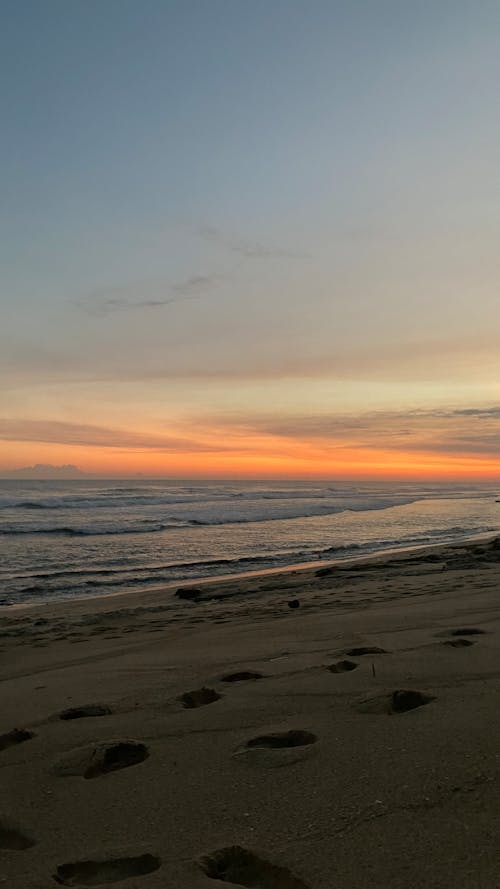 View of a Beach with Footprints in the Sand at Sunset