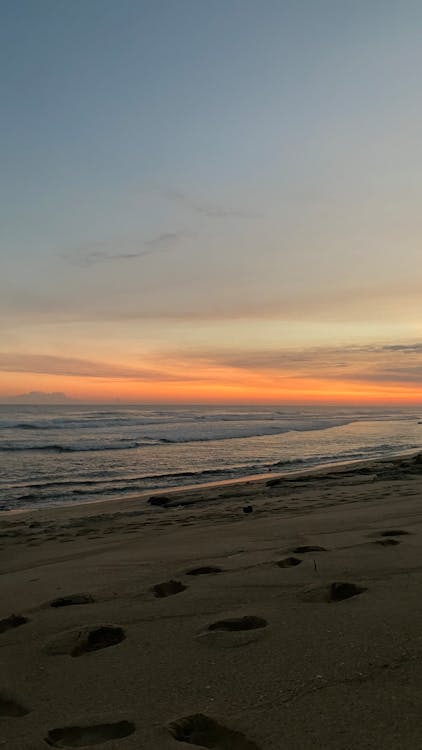 View of a Beach with Footprints in the Sand at Sunset
