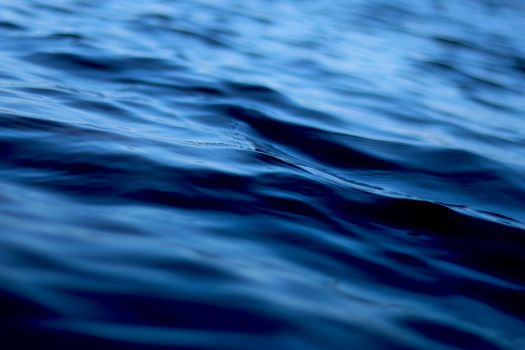Close-up view of calm blue water ripples with smooth reflections and natural lighting.