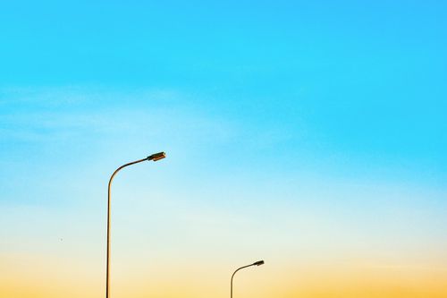 Free A minimalist scene of streetlights with a vibrant gradient sky at sunset, perfect for modern design. Stock Photo