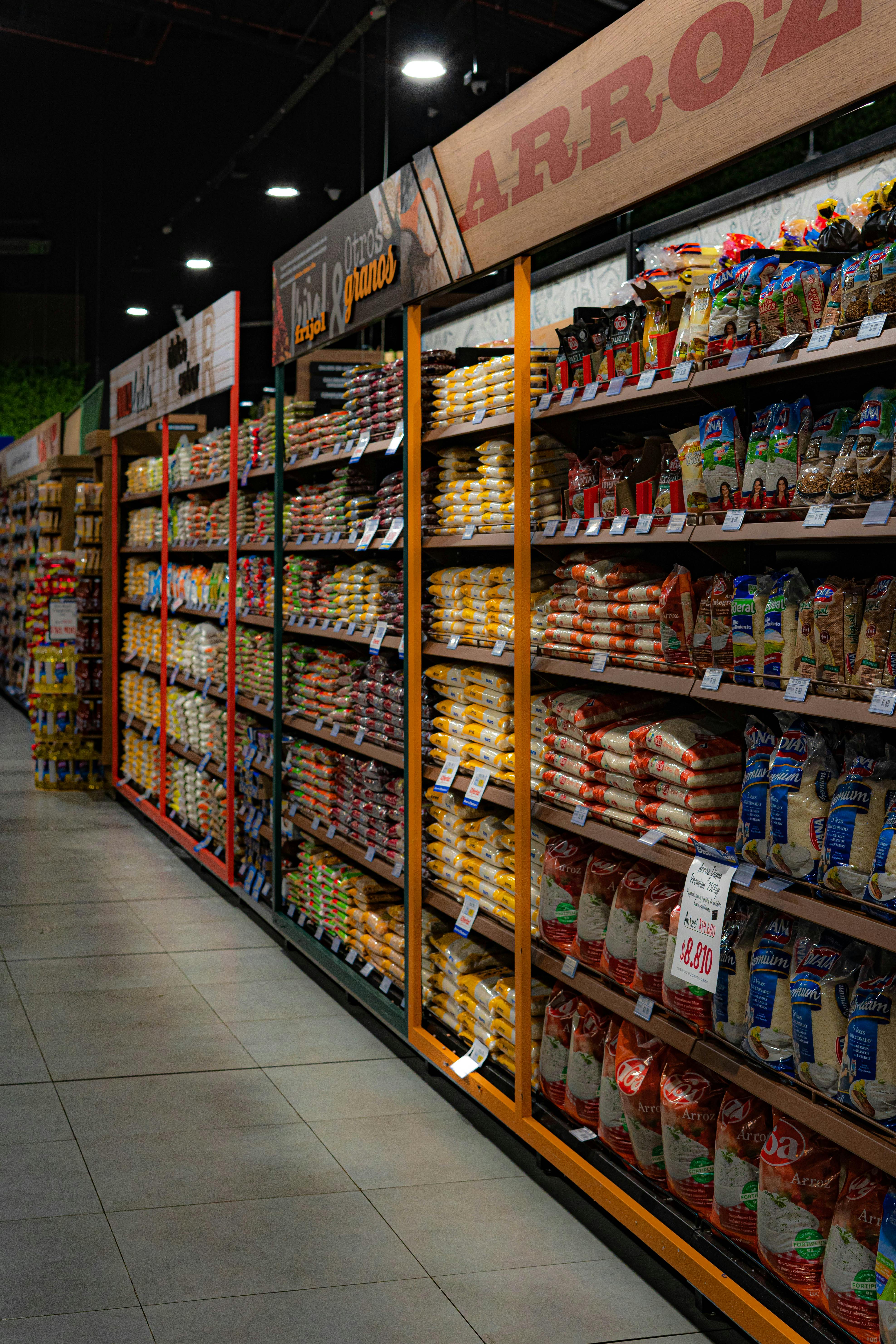 A grocery store aisle filled with various rice and grain packages neatly organized on shelves.