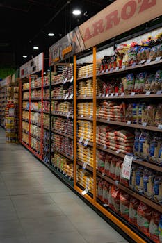 A grocery store aisle filled with various rice and grain packages neatly organized on shelves.