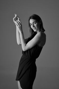Chic fashion portrait of a Caucasian woman in a dress, captured in a studio.