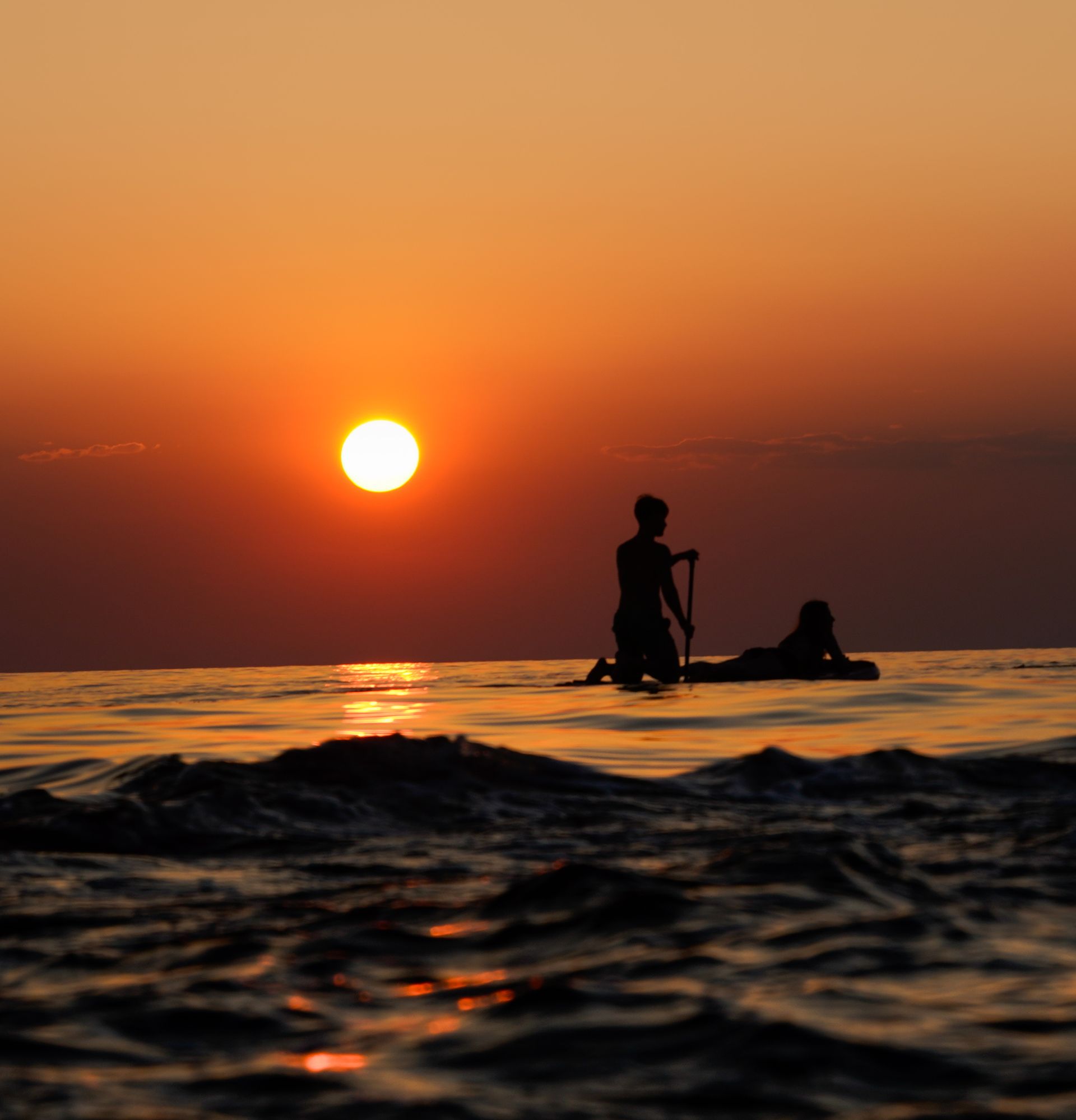 Paddleboarders at sunset