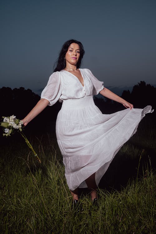 Woman in a White Summer Dress on a Meadow at Night