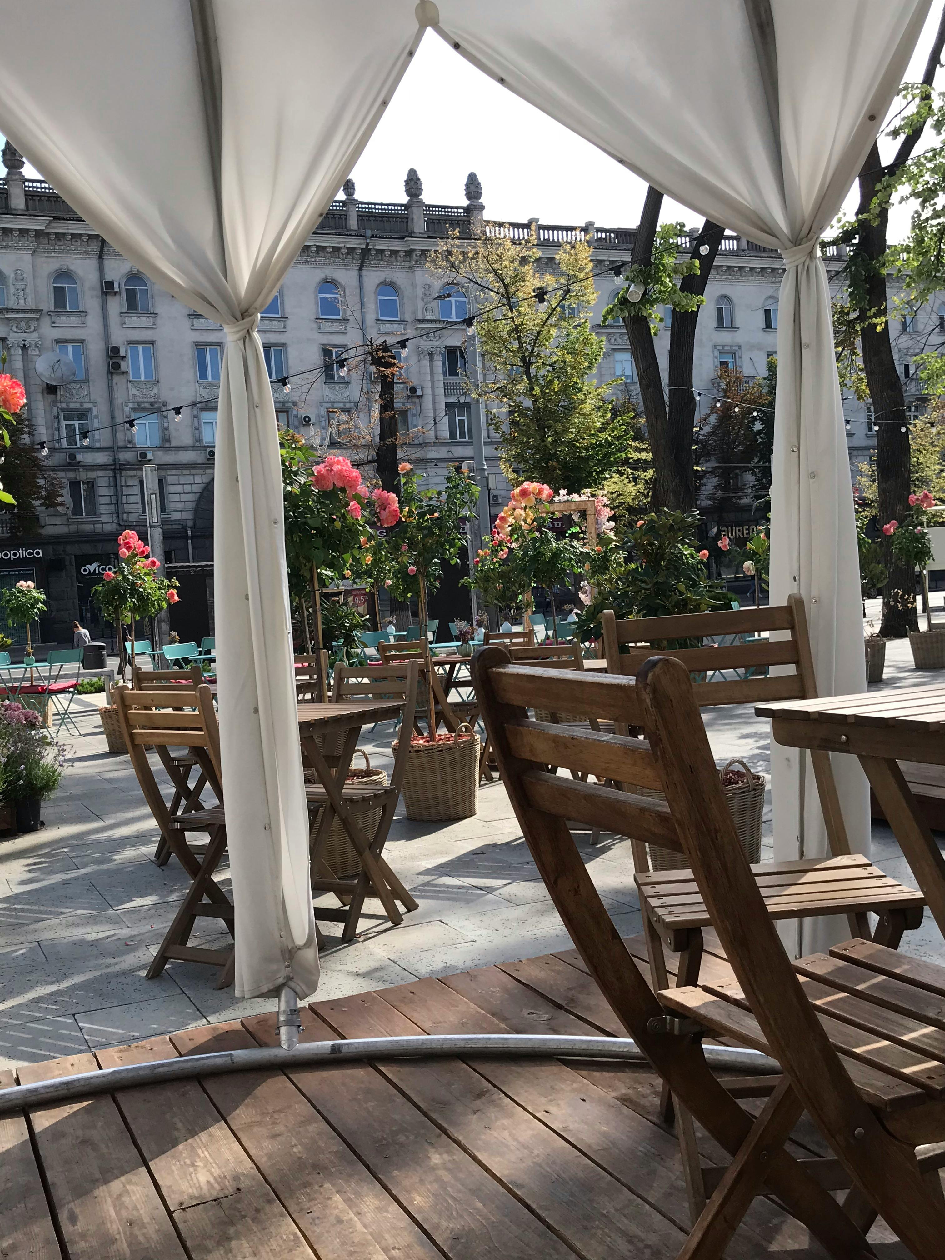 a patio with tables and chairs and a canopy