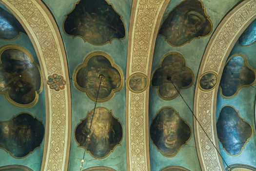 Intricate church ceiling featuring ornate arches and detailed frescoes, creating an artistic and spiritual ambiance.