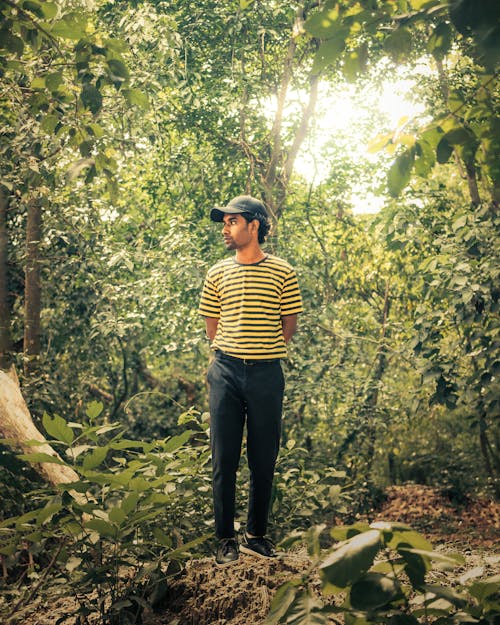Man in a Striped T-shirt Standing in a Forest