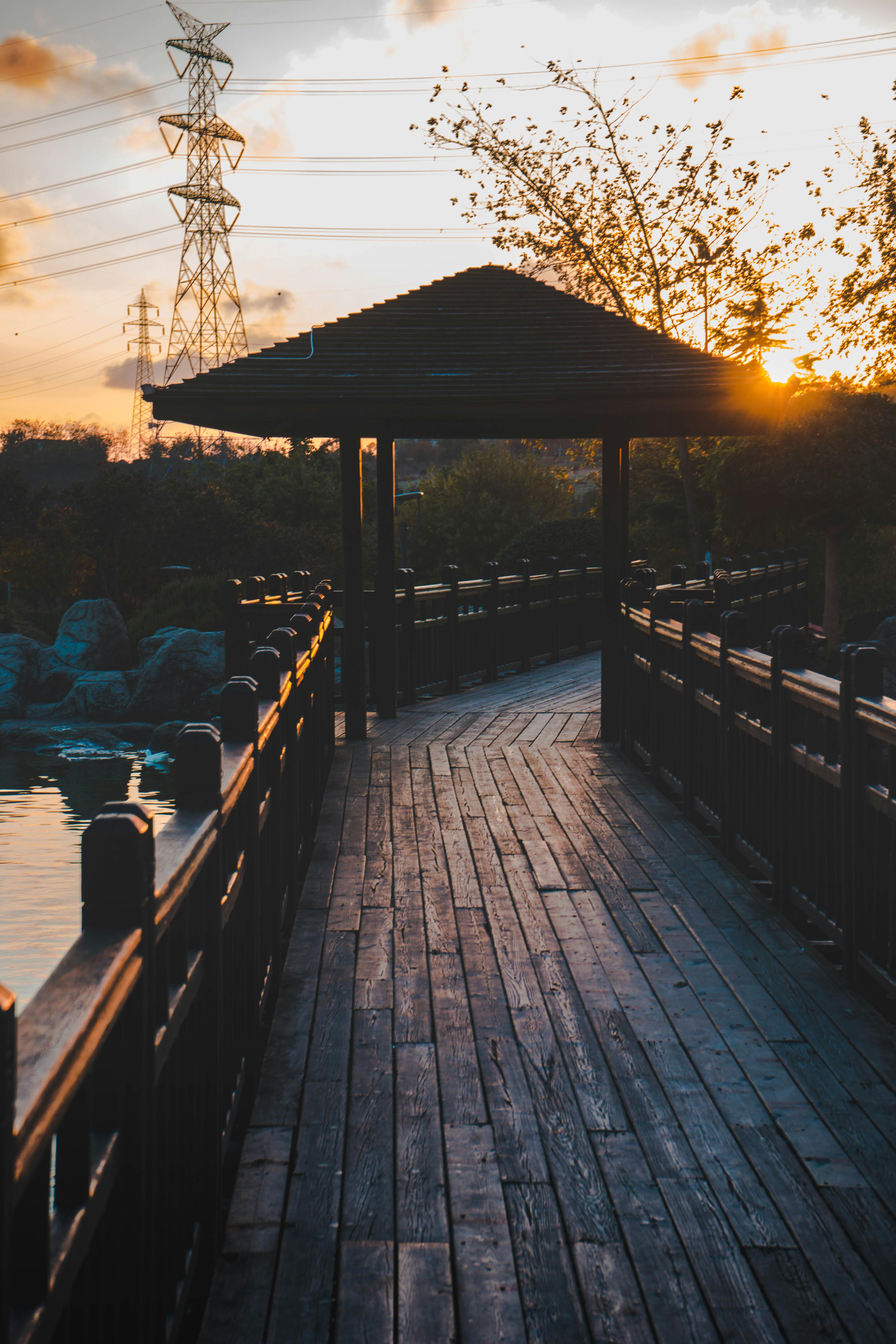 湖畔木制小路上，日落景观宁静优美，屋顶悬挑其间