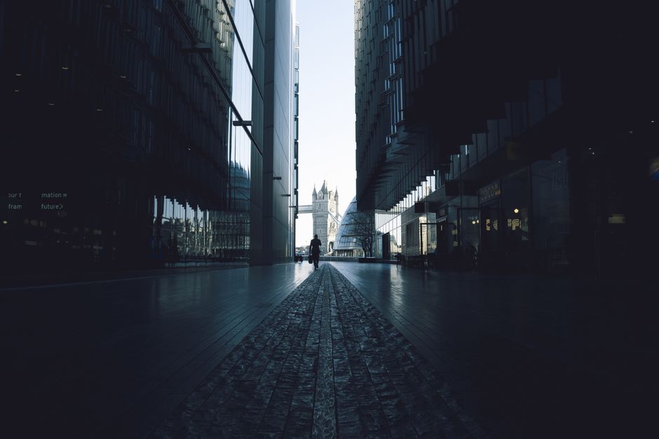 Dramatic urban scene in London showcasing the iconic Tower Bridge framed by modern architecture.