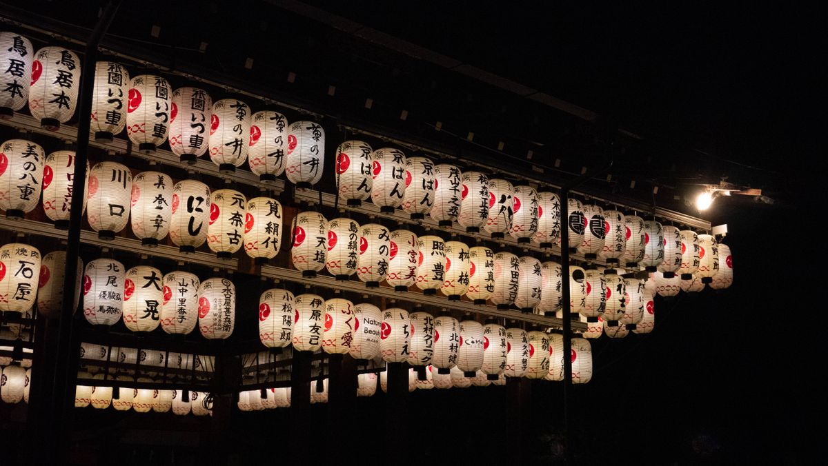 Traditional Japanese lanterns illuminating a night street market, reflecting the festive evening atmosphere of the Aomori region