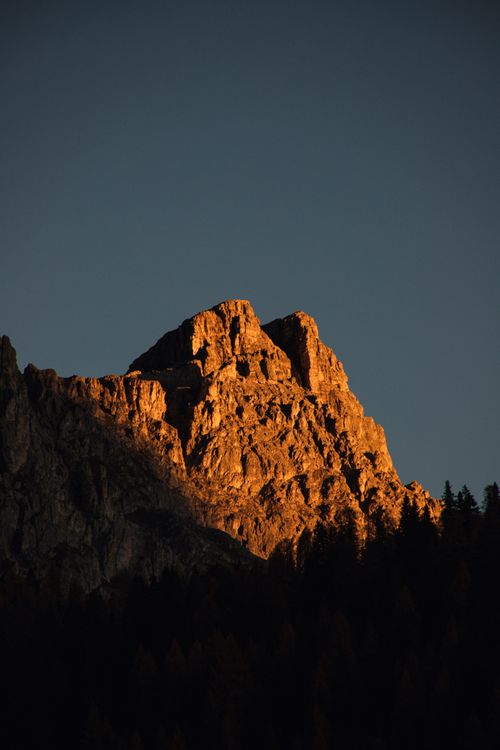 Free Sunset over a rugged mountain peak in the Dolomites, Italy, with dramatic lighting and natural beauty. Stock Photo