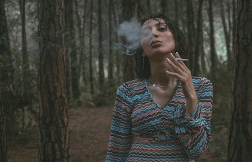 Woman Smoking a Cigarette in a Forest