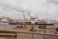 一艘渡轮驶过繁忙的港口，城市天际线作为背景