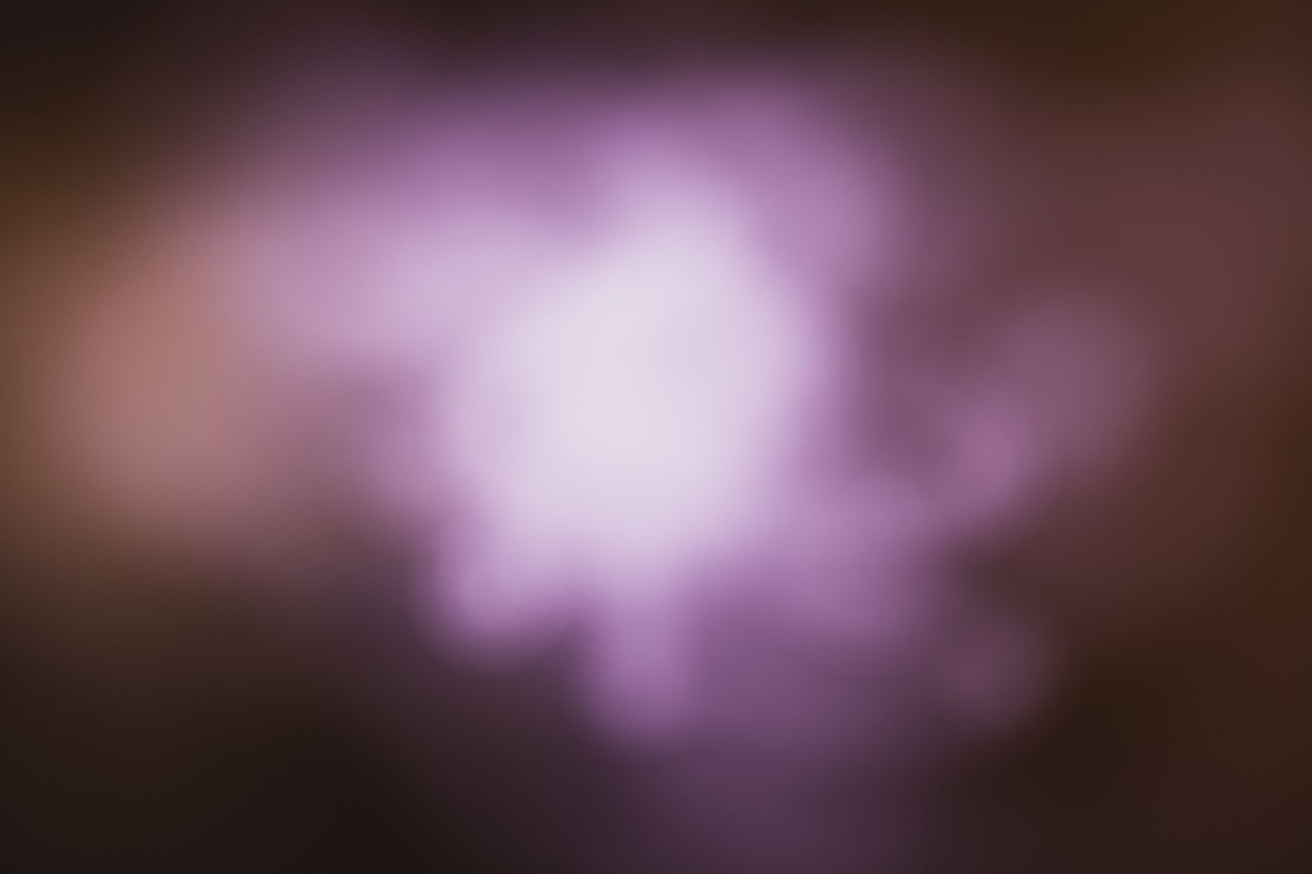 A vibrant abstract background with a blurred purple glow and soft focus effect.