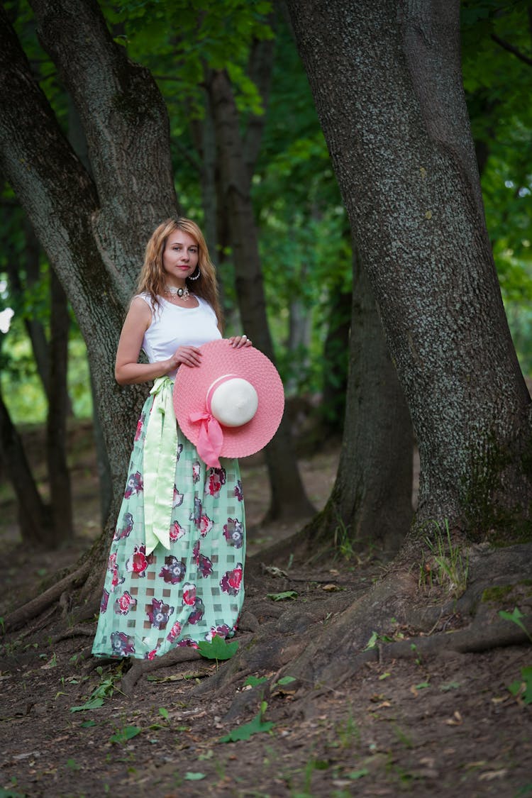 Woman In Skirt Posing With Hat In Forest