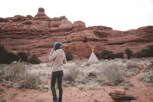 бесплатная Женщина, стоящая возле палатки и скального образования Стоковое фото