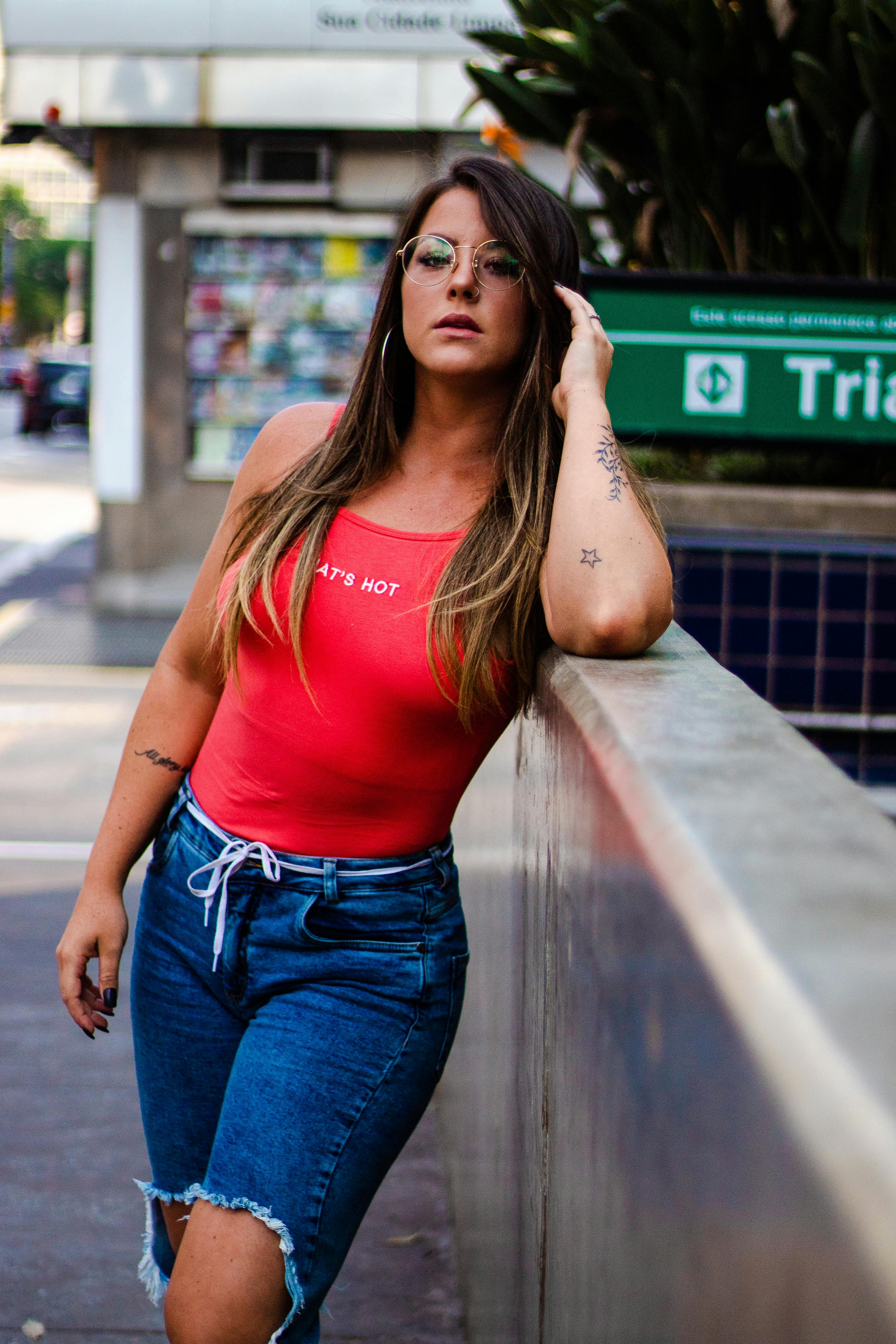 一位身着缤纷服装的时尚女士在城市中自信摆拍，展现了现代街头风格