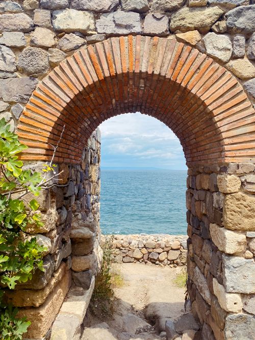 Free Scenic view through a stone archway with sea backdrop in Sozopol, Bulgaria. Stock Photo