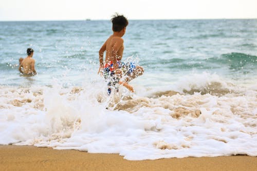 海に向かって急いでいる少年の写真