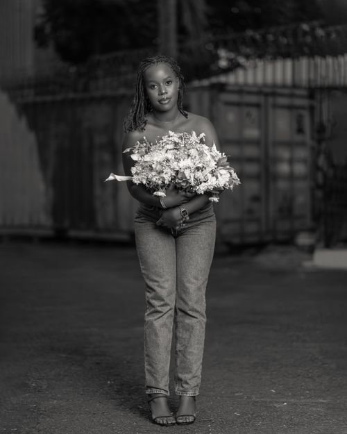Free Black and white portrait of a woman holding a bouquet of flowers, capturing serene elegance. Stock Photo