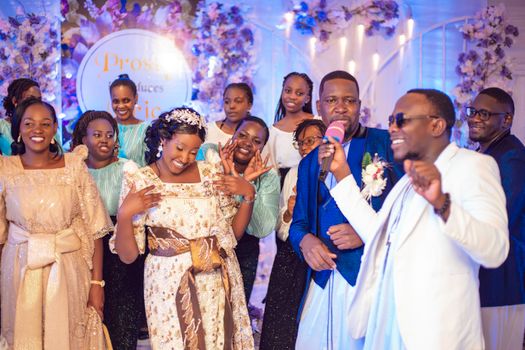 A large group celebrating a joyous wedding with singing and dancing.