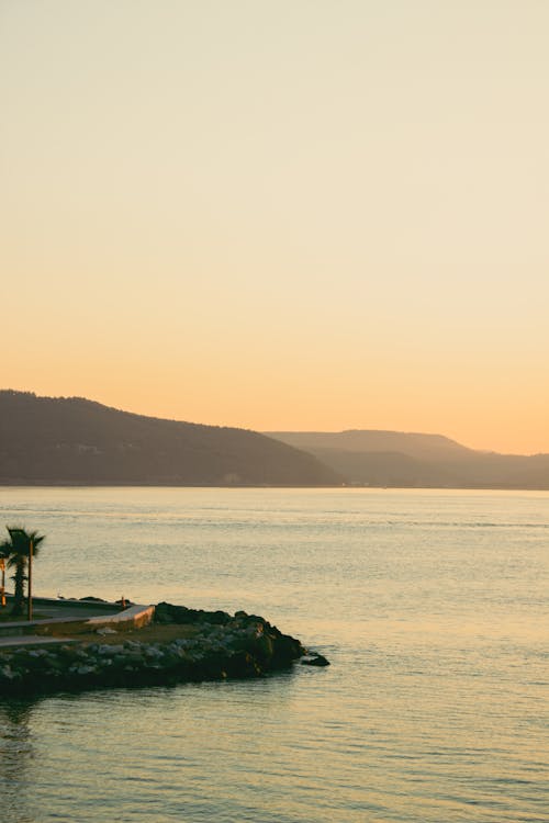 Clear Yellow Sky over Sea Shore at Sunset