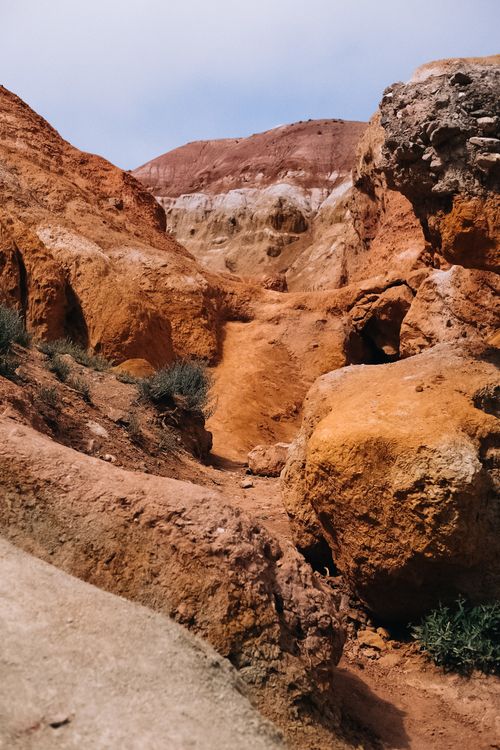 Free Vibrant red and orange rocky formations in a dry, desert canyon setting. Stock Photo