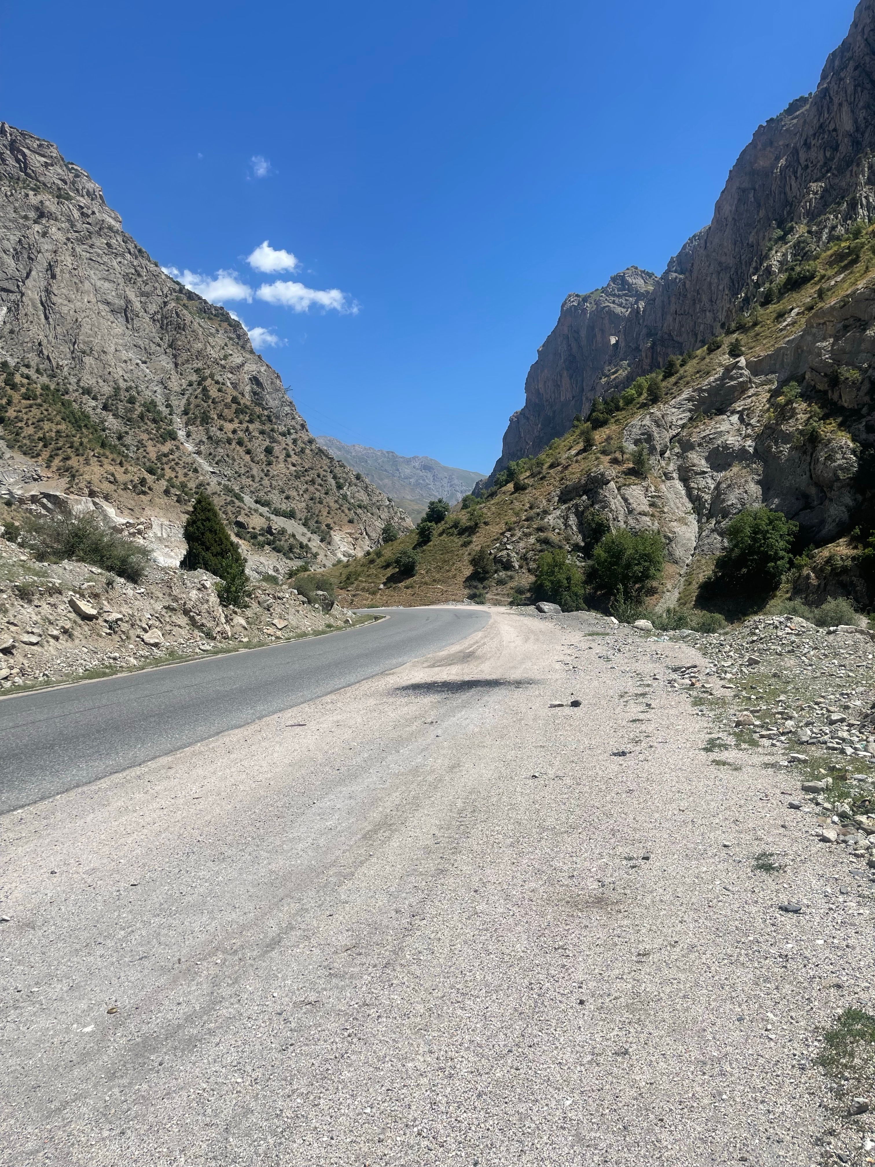Winding mountain road cutting through dramatic rocky peaks in Central Asia